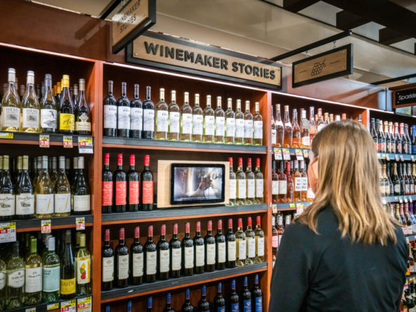 Person looking at Loop tablet in front of grocery store wine